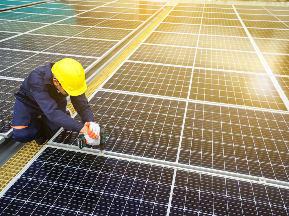 Certified installer securing solar panels at sunset